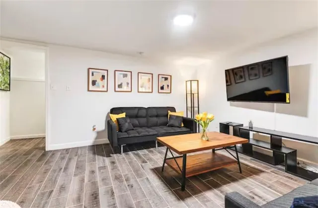 a view of a dining room and livingroom with furniture wooden floor a chandelier