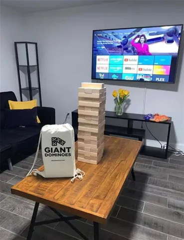 a living room with furniture a flat screen tv and a large window