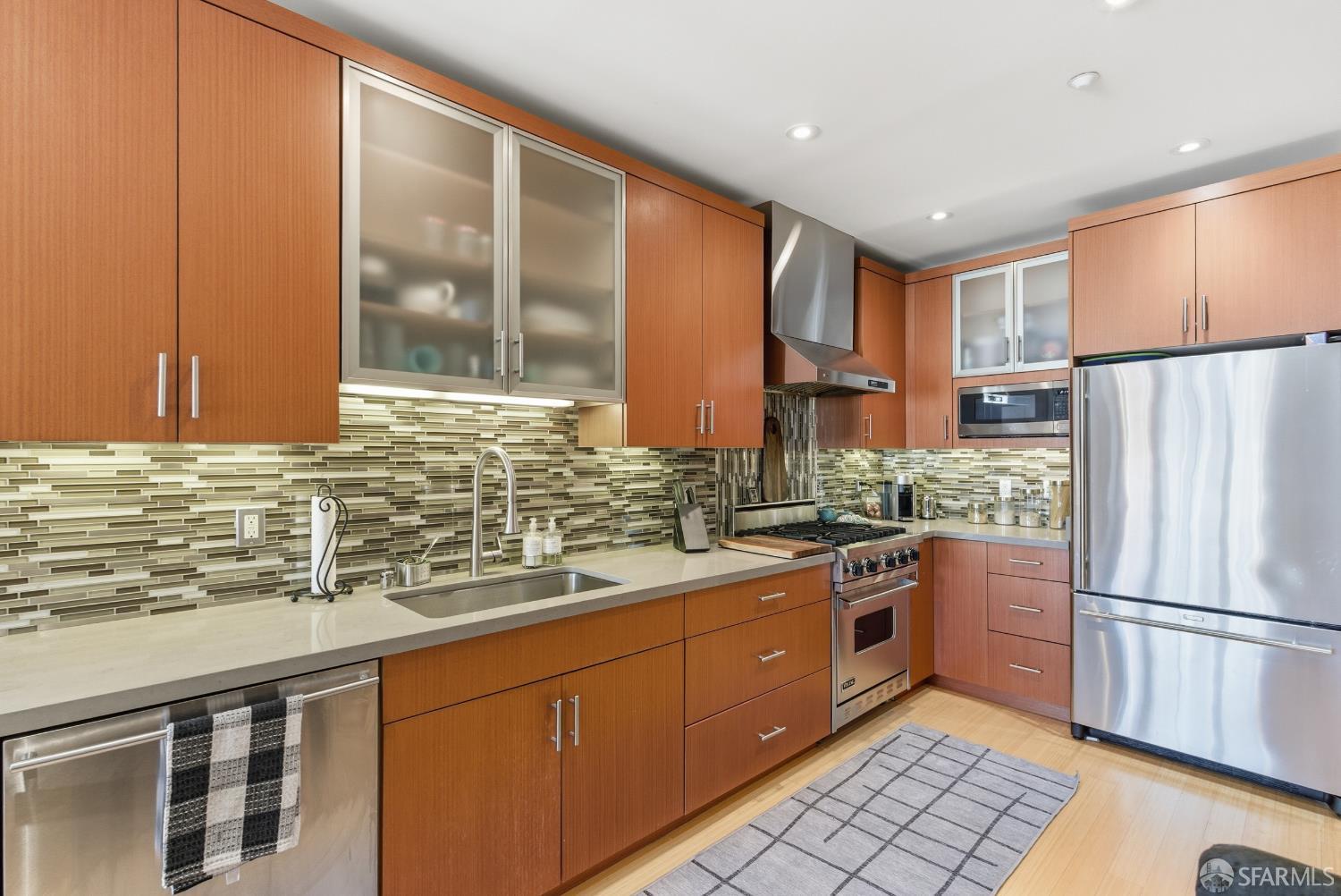 1725 Washington Street, Unit 9 San Francisco, CA 94109 - Photo 6 of 13 a kitchen with stainless steel appliances granite countertop a refrigerator and a sink
