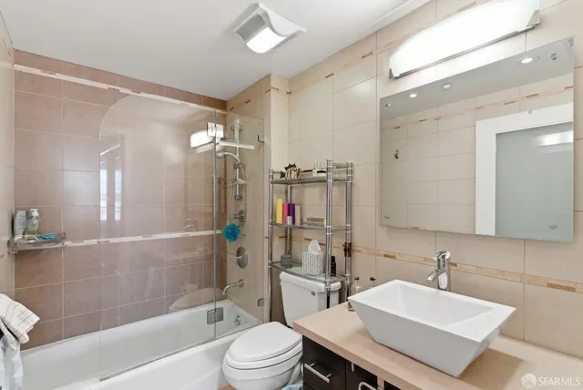 a bathroom with a sink a toilet a mirror and shower