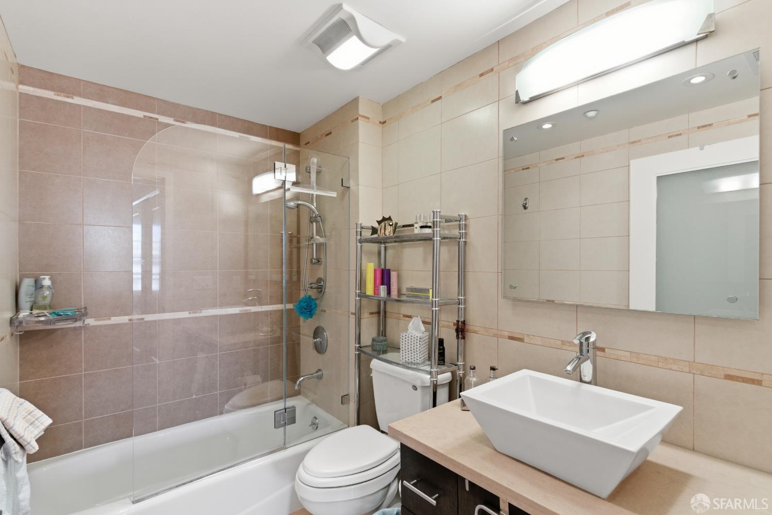 1725 Washington Street, Unit 9 San Francisco, CA 94109 - Photo 10 of 13 a bathroom with a sink a toilet a mirror and shower