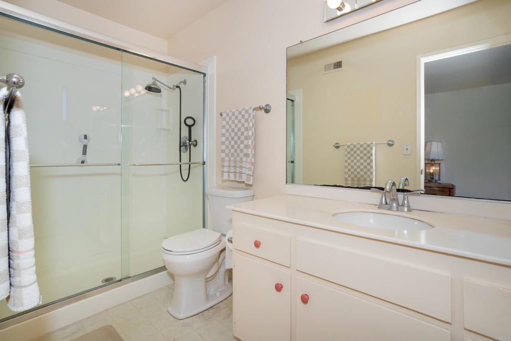 4427 Trieste Drive Carlsbad, CA 92010 - Photo 18 of 24 a bathroom with a granite countertop sink toilet and shower