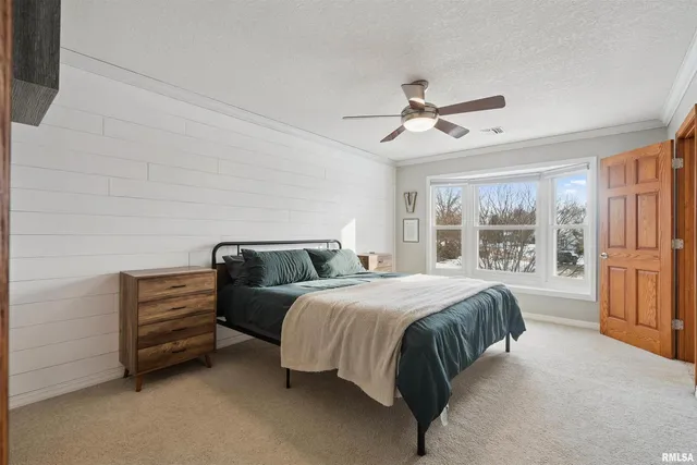 a spacious bedroom with a bed and a chandelier