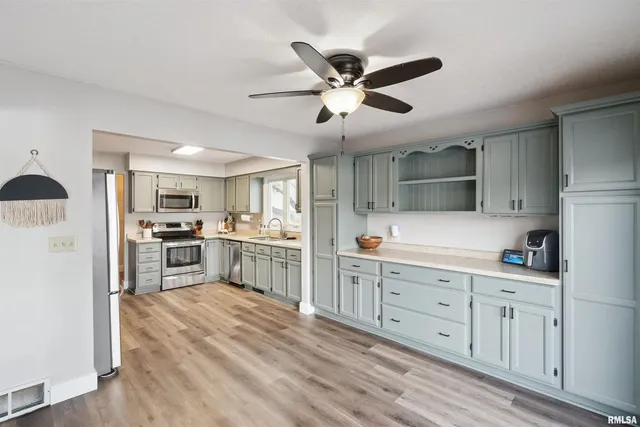 a kitchen with white cabinets and stainless steel appliances