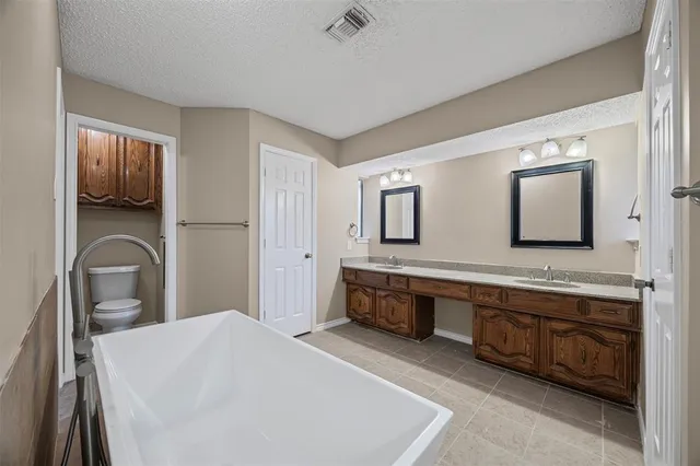 a spacious bathroom with a double vanity sink and a mirror