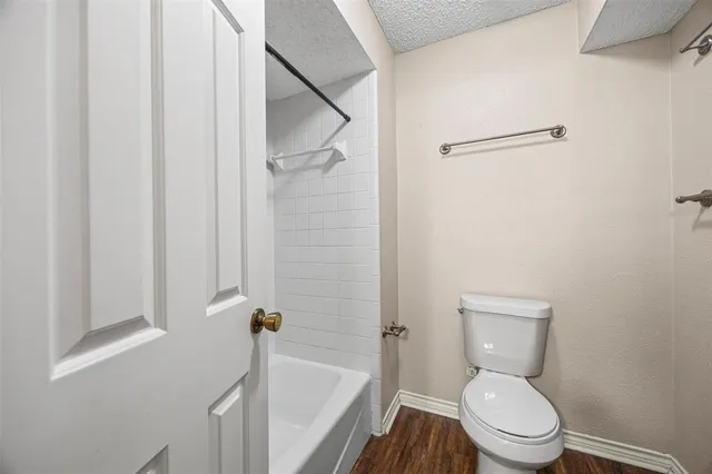 a white toilet sitting next to a bath tub