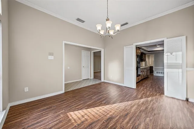 a view of a livingroom with wooden floor and kitchen space