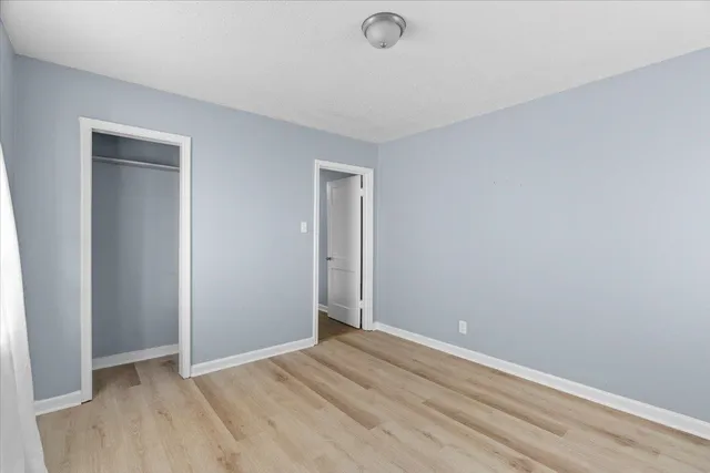 an empty room with wooden floor and closet