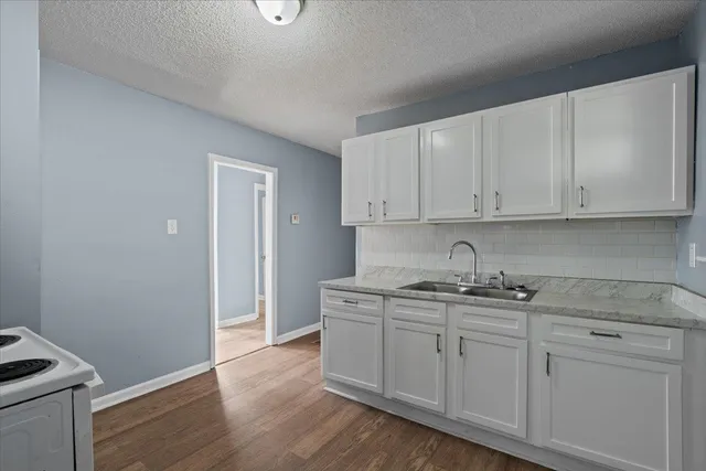 a kitchen with stainless steel appliances granite countertop a sink and dishwasher with white cabinets