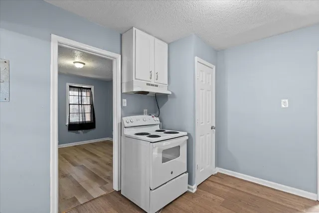 a kitchen with granite countertop white cabinets and white appliances
