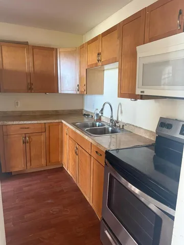 a kitchen with stainless steel appliances granite countertop a sink stove and cabinets