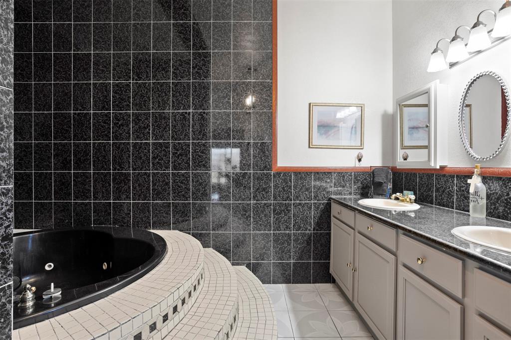 6524 Fair Road Kaufman, TX 75142 - Photo 19 of 30 a bathroom with a bathtub a sink a toilet a mirror and vanity