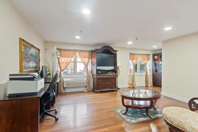 a living room with furniture a window and a flat screen tv