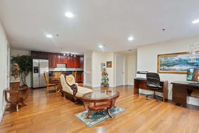 a living room with furniture pool table and kitchen view