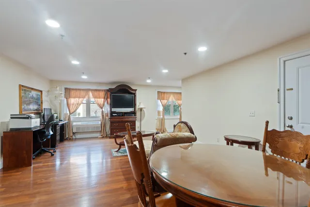 a living room with furniture a flat screen tv and wooden floor