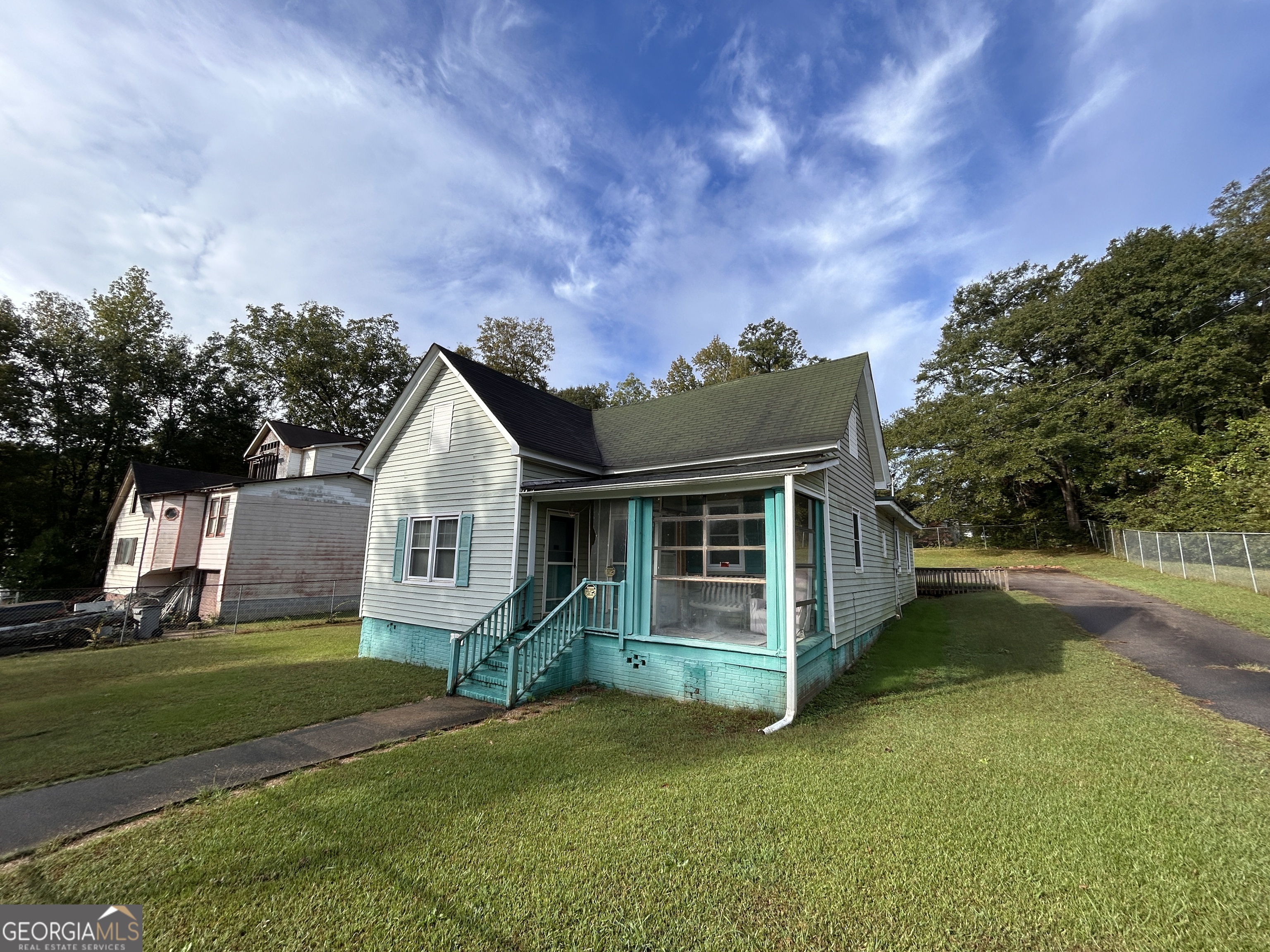 a view of a house with a big yard plants and large trees