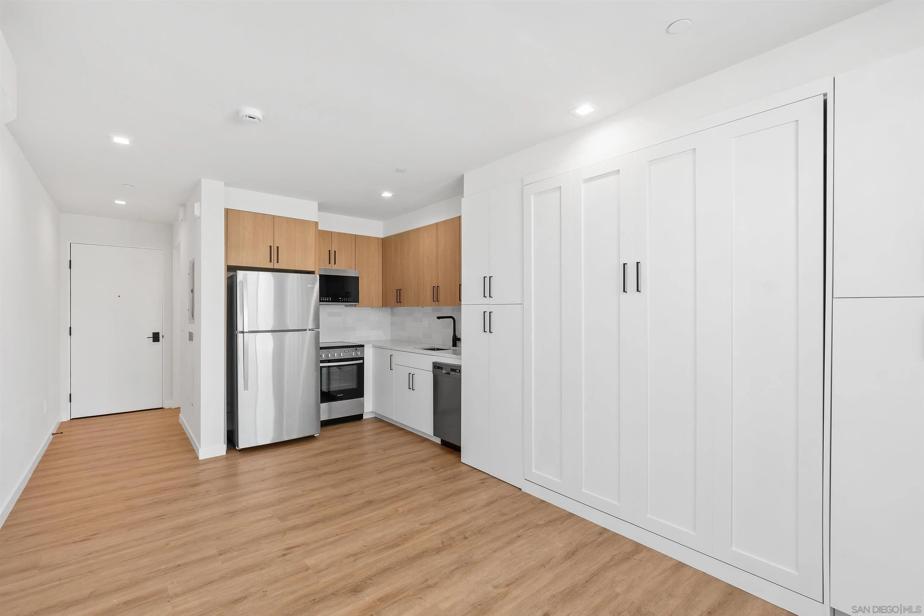 1111 Torrey Pines Road, Unit 203 La Jolla, CA 92037 - Photo 6 of 10 a kitchen with stainless steel appliances a refrigerator and a stove top oven