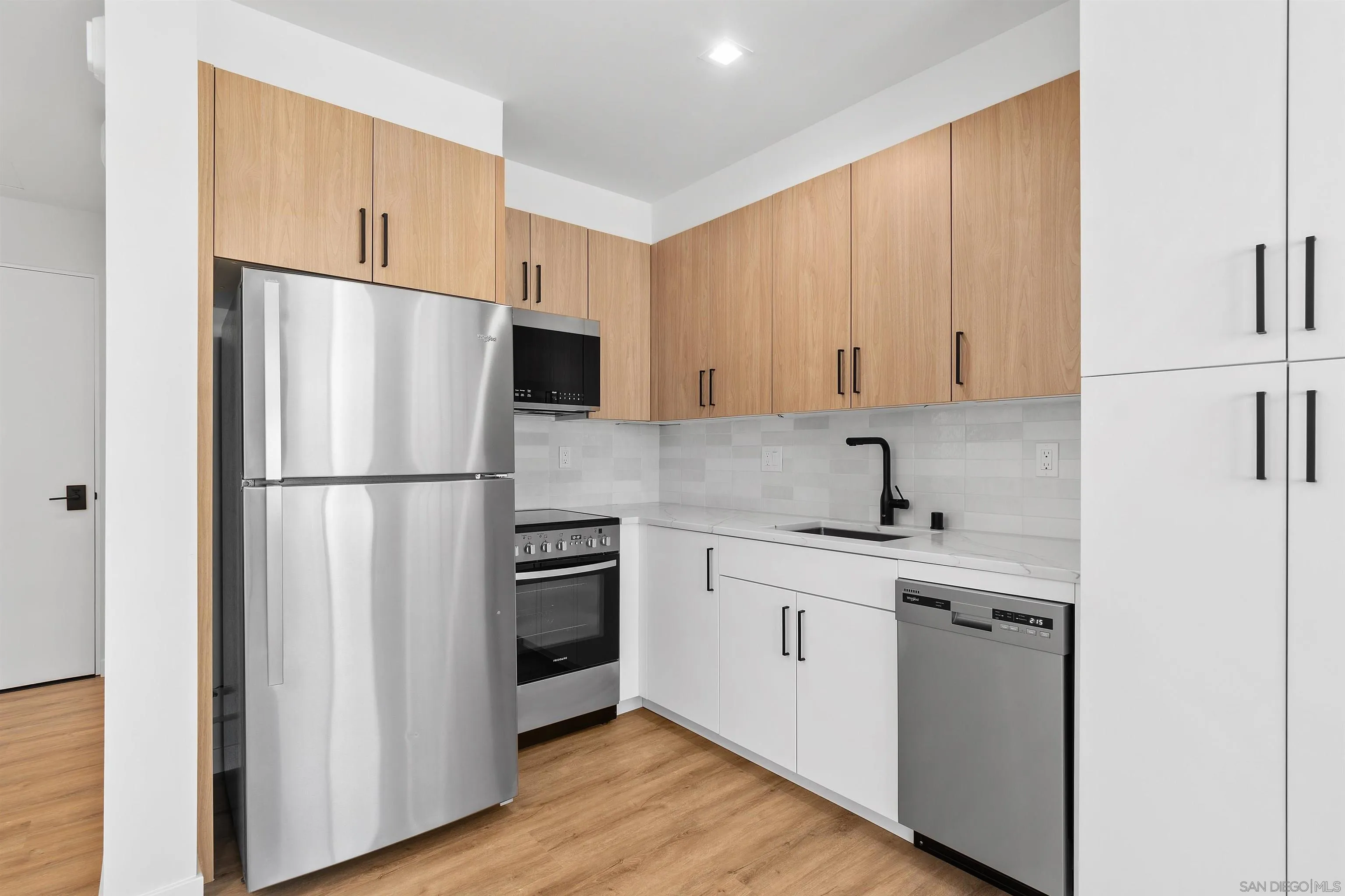 1111 Torrey Pines Road, Unit 203 La Jolla, CA 92037 - Photo 7 of 10 a kitchen with stainless steel appliances a refrigerator sink and cabinets