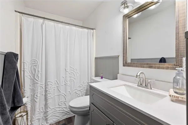 a bathroom with a granite countertop sink toilet and shower