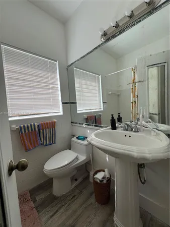 a bathroom with a sink toilet and a mirror