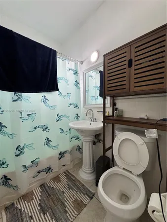 a bathroom with a toilet sink and mirror