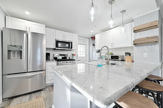 a kitchen with stainless steel appliances granite countertop a sink refrigerator and microwave