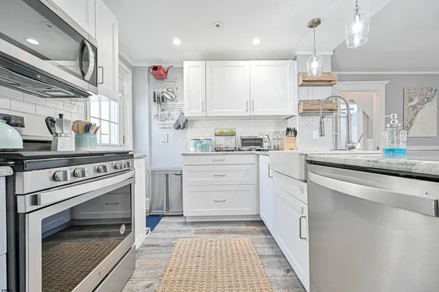 a kitchen with white cabinets and appliances