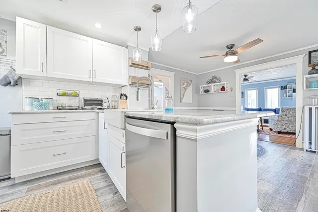 a kitchen with kitchen island granite countertop a sink cabinets and stainless steel appliances