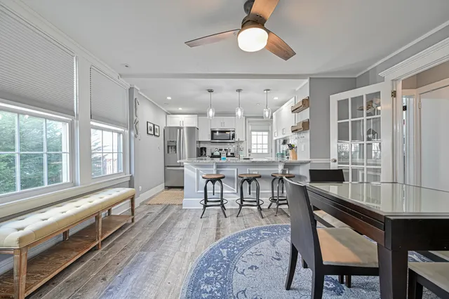 a living room with stainless steel appliances kitchen island granite countertop furniture and a wooden floor
