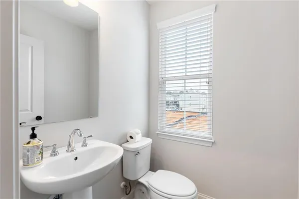 a bathroom with a sink a toilet and a window