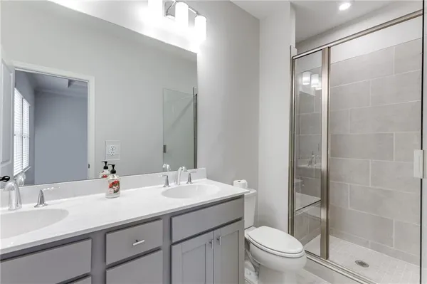 a bathroom with a double vanity sink toilet and shower