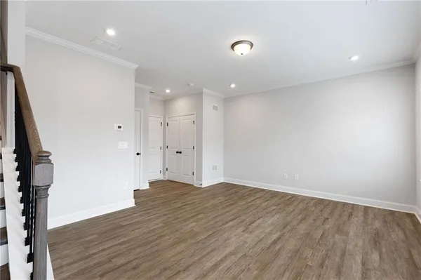an empty room with wooden floor and entryway