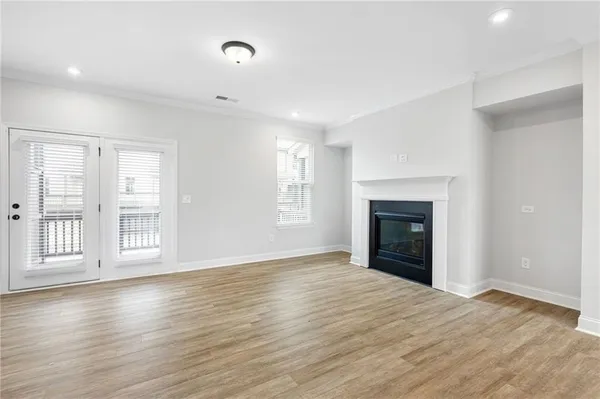 a view of an empty room with a fireplace and a window