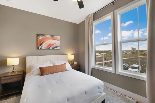 a bedroom with a bed and a large window