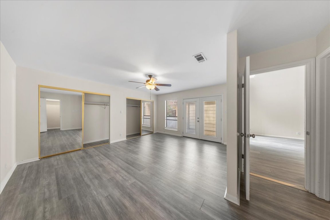 10900 Crown Colony Drive, Unit B Austin, TX 78747 - Photo 13 of 26 a view of an empty room with window and wooden floor