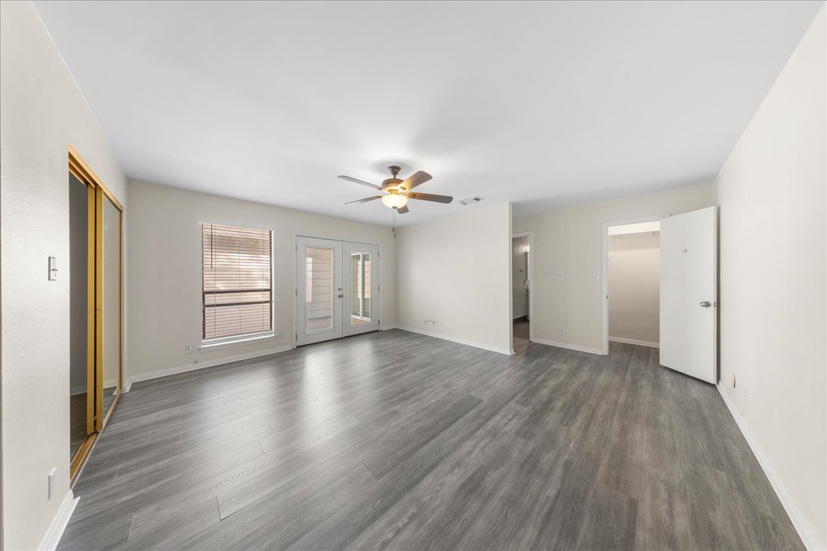 10900 Crown Colony Drive, Unit B Austin, TX 78747 - Photo 14 of 26 wooden floor in an empty room with a window
