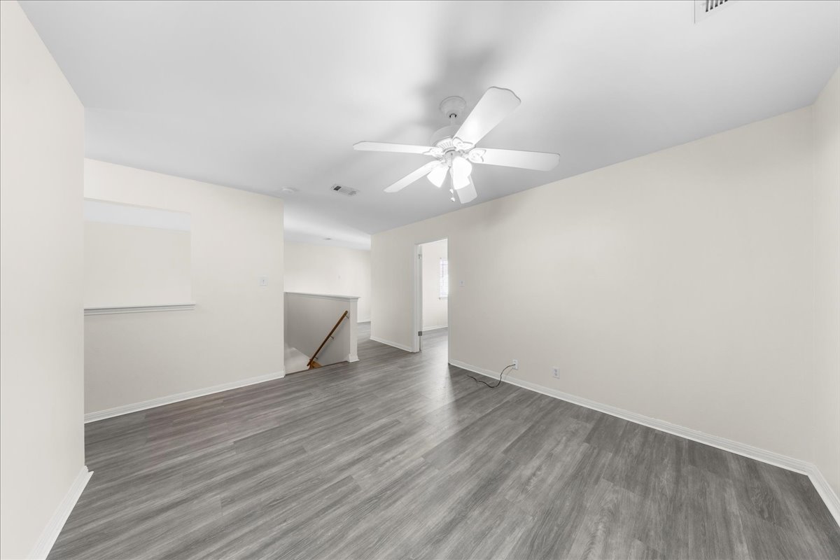 10900 Crown Colony Drive, Unit B Austin, TX 78747 - Photo 18 of 26 an empty room with wooden floor and fan
