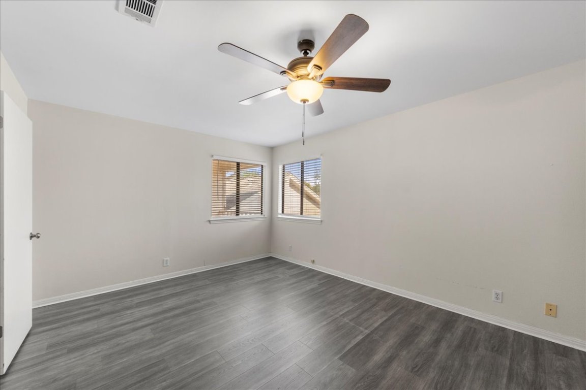 10900 Crown Colony Drive, Unit B Austin, TX 78747 - Photo 21 of 26 an empty room with wooden floor and ceiling fan