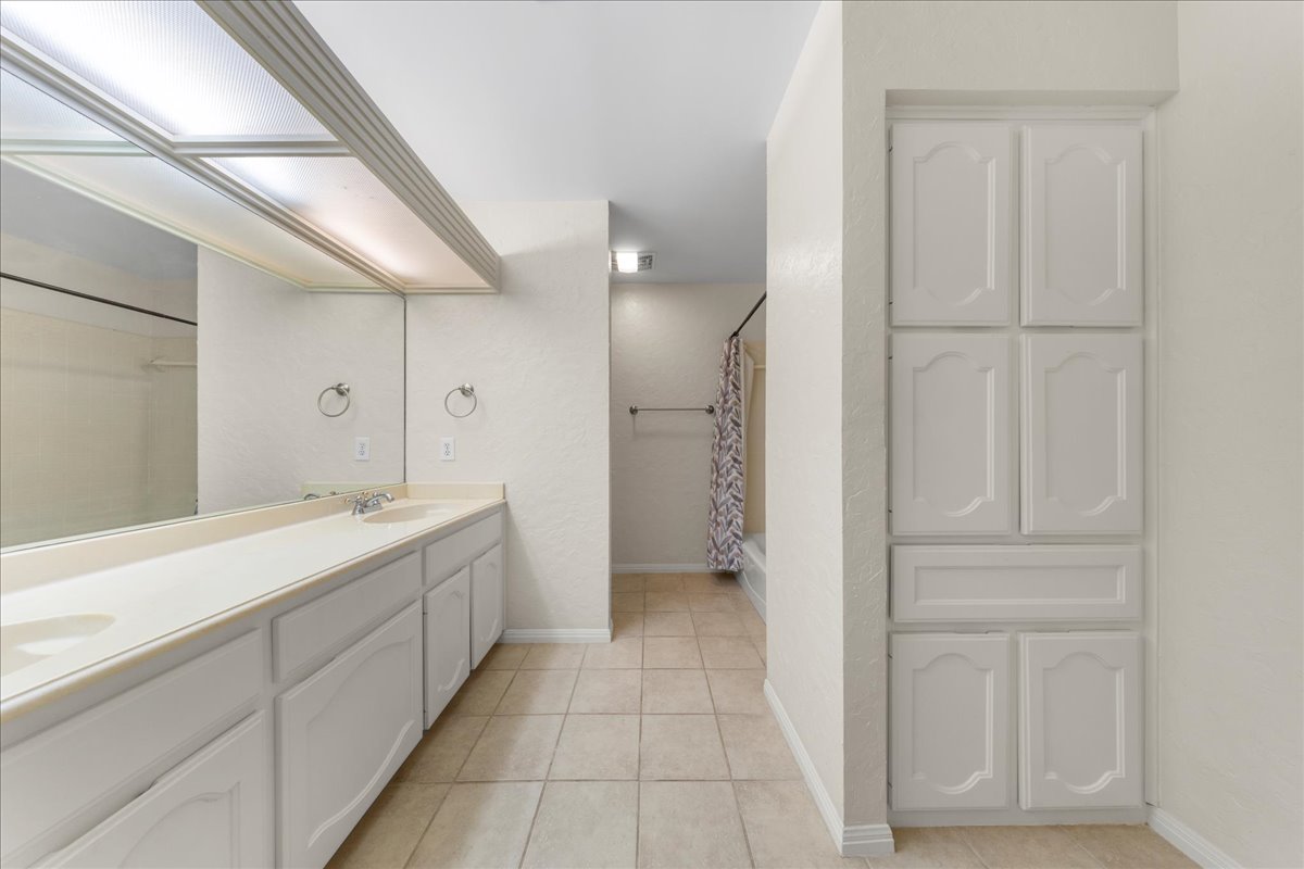 10900 Crown Colony Drive, Unit B Austin, TX 78747 - Photo 22 of 26 a bathroom with a double vanity sink and mirror
