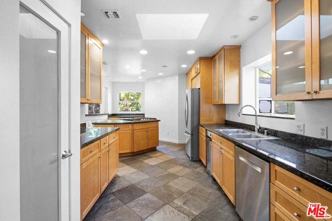 10453 Holman Avenue Los Angeles, CA 90024 - Photo 14 of 67 a large kitchen with stainless steel appliances kitchen island granite countertop a sink and cabinets