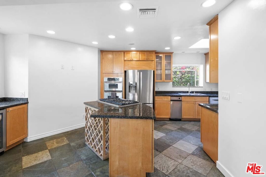 10453 Holman Avenue Los Angeles, CA 90024 - Photo 20 of 67 a kitchen with stainless steel appliances granite countertop a sink a stove and a refrigerator