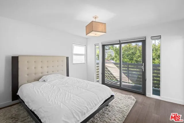 an empty room with wooden floor fireplace and windows