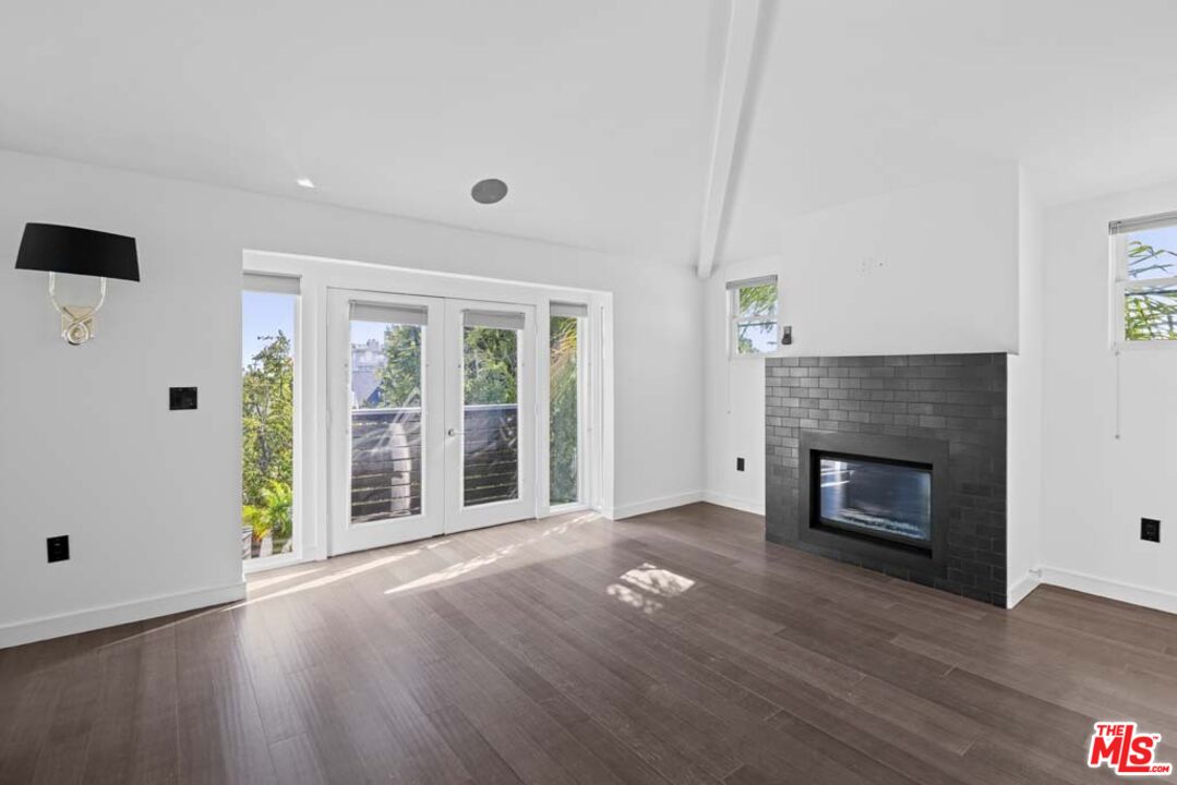 10453 Holman Avenue Los Angeles, CA 90024 - Photo 47 of 67 an empty room with wooden floor fireplace and windows