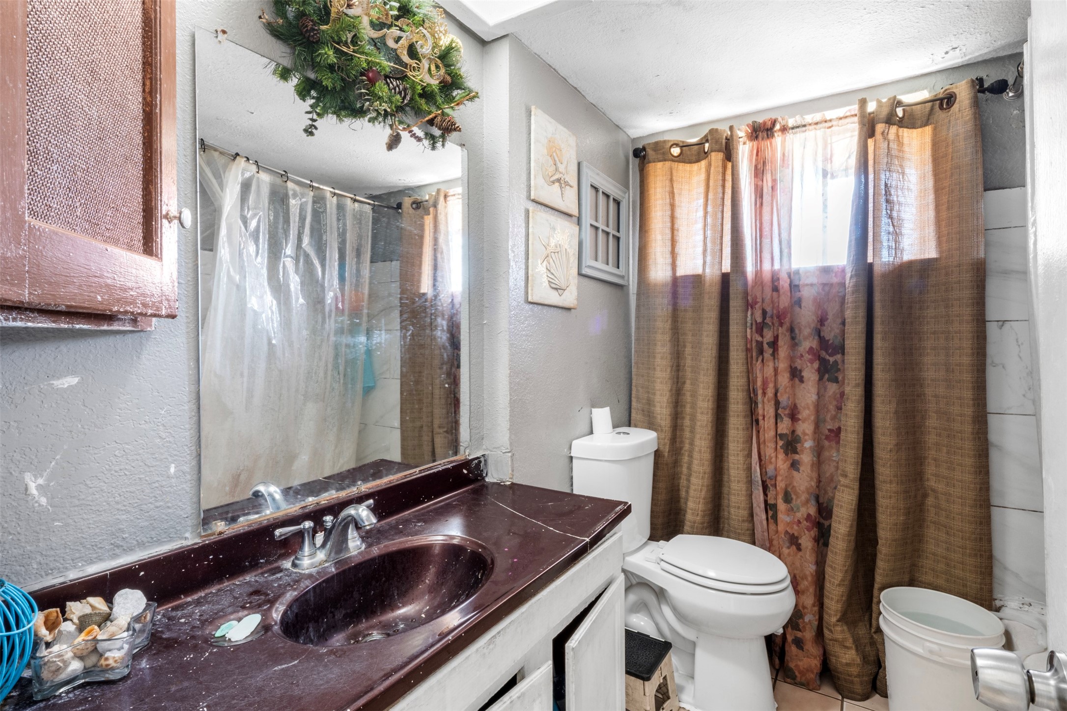 7726 Boggess Road Houston, TX 77016 - Photo 12 of 30 a bathroom with a sink a toilet a mirror and shower