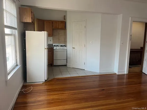 a view of kitchen with refrigerator cabinets and wooden floor