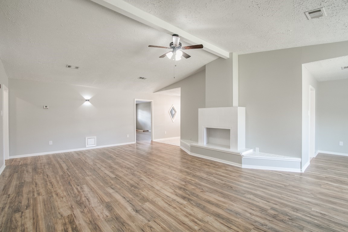1343 Littleport Lane Channelview, TX 77530 - Photo 3 of 33 an empty room with wooden floor ceiling fan and windows