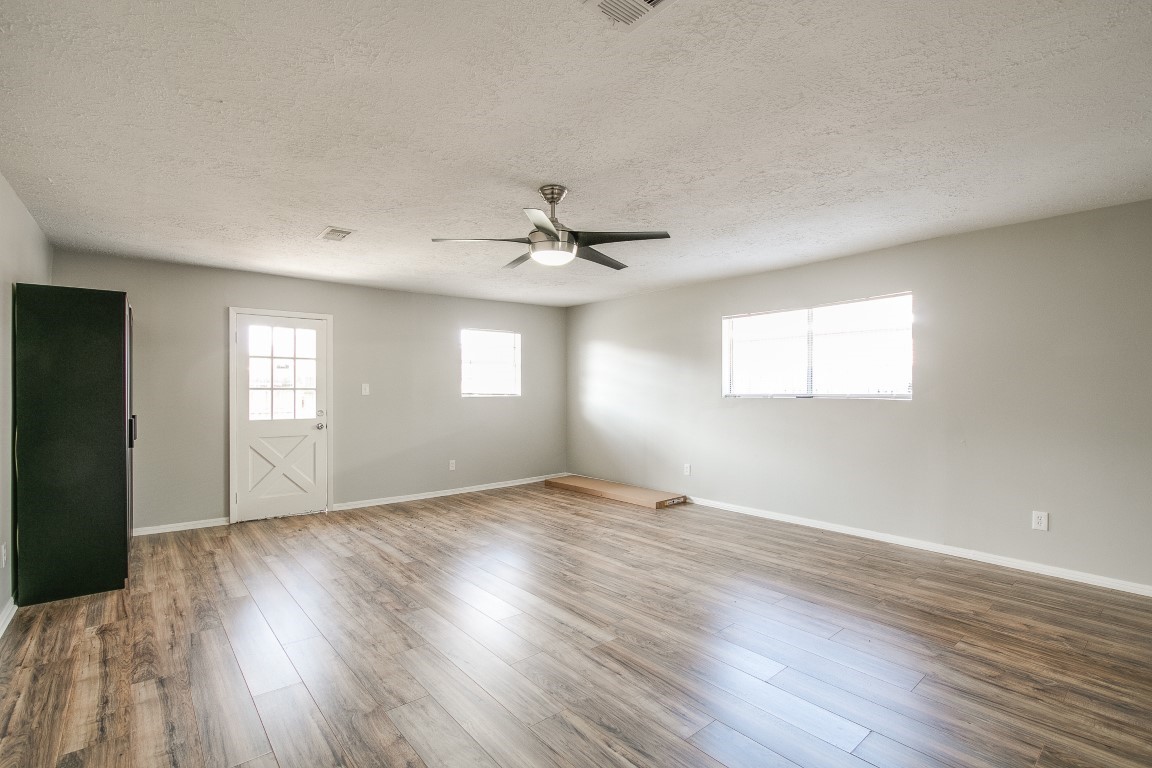 1343 Littleport Lane Channelview, TX 77530 - Photo 7 of 33 a view of an empty room with wooden floor and a window