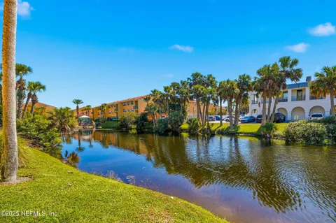 a view of a swimming pool with a yard and palm trees