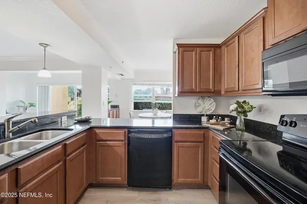 a kitchen with granite countertop a sink stove and refrigerator