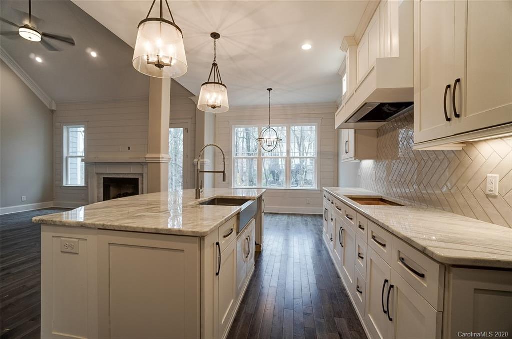 684 Portpatrick Place Fort Mill, SC 29708 - Photo 11 of 25 a kitchen with stainless steel appliances granite countertop a sink a stove oven a kitchen island with wooden cabinets and floor